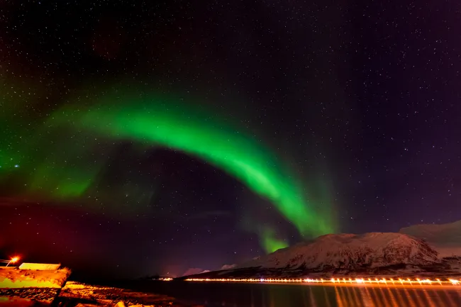 Northern lights over the Solenagen fjord in front of the Lyngenfjord Alps