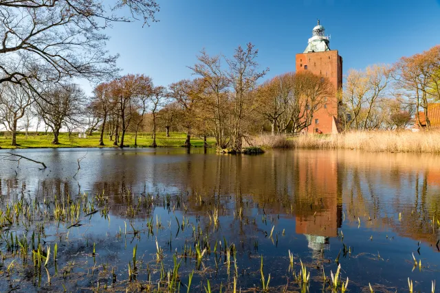 Der Leuchtturm spiegelt sich im Teich des Herrengartens