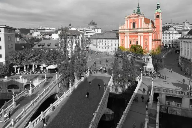 Die "Drei Brücken" von Ljubljana mit der roten Franziskanerkirche "Mariä Verkündigung" 