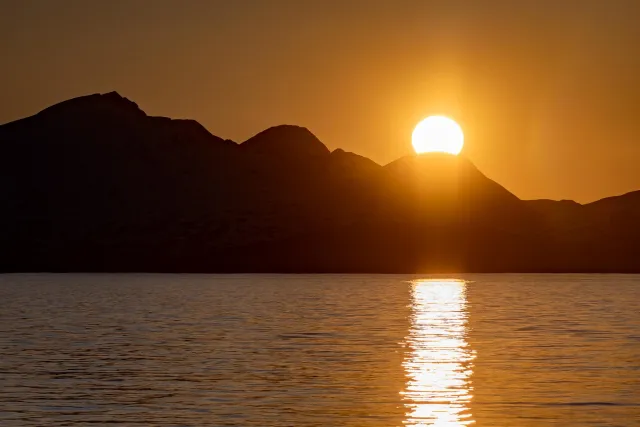 The midnight sun over the island of Reinøya in the Ullsfjord in Norway