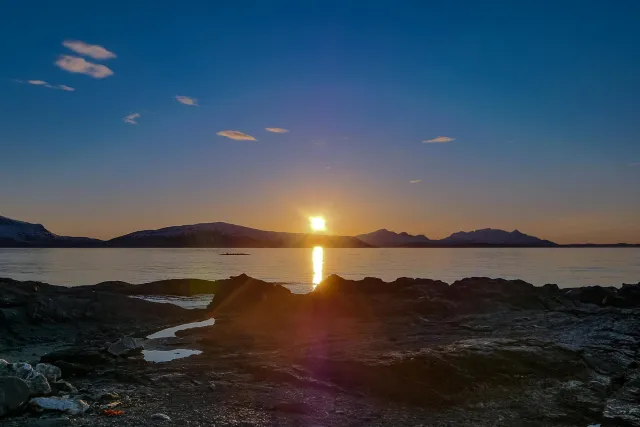 Die Mitternachtssonne über der Insel Reinøya im Ullsfjord in Norwegen