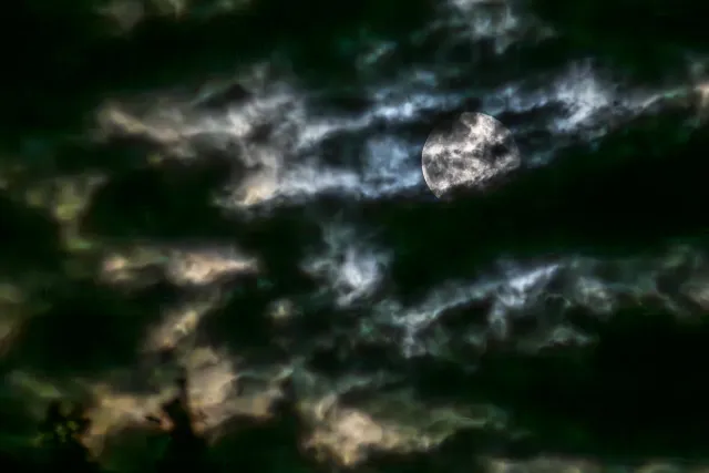 Super moon as a blue moon behind clouds over Röttgen in Hennef