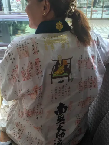 Eine Pilgerin zeigt uns im Bus stolz ihre Stempel vom Pilgerweg in Shikoko