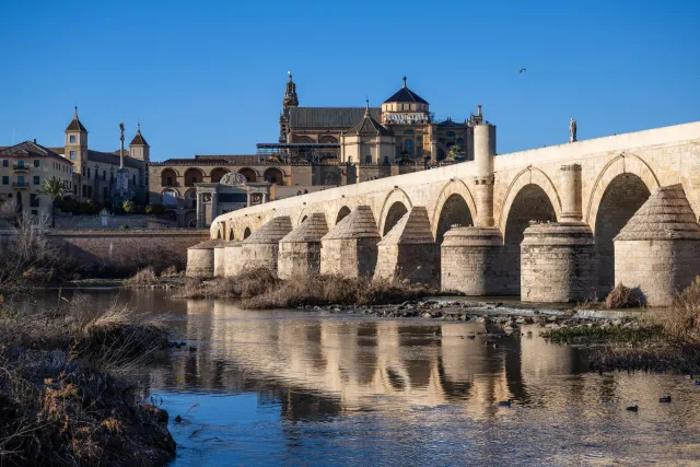 Abend über dem Guadalquivir – die Brücke im Licht, die Mezquita im Gold, und zwischen beidem der Atem der Geschichte.